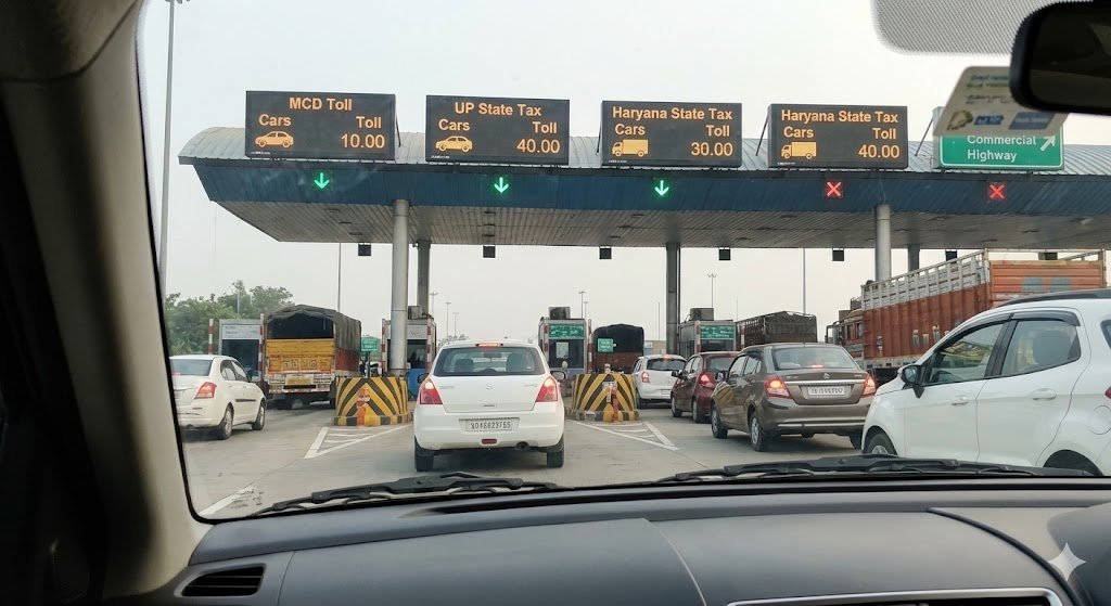 a view from inside a car at a toll plaza showing various state tax and mcd toll charges, illustrating hidden costs in cab travel.